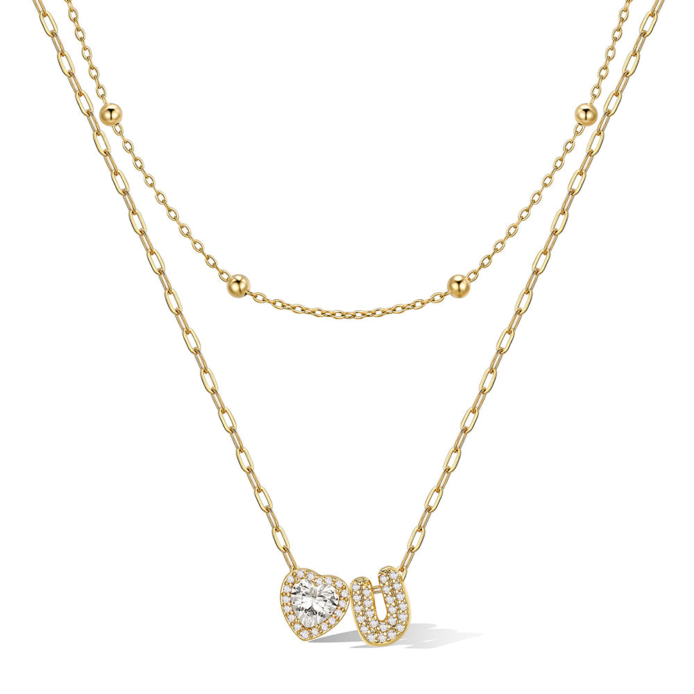 Gold cz bubble initial U necklace with a heart-shaped pendant on a white background