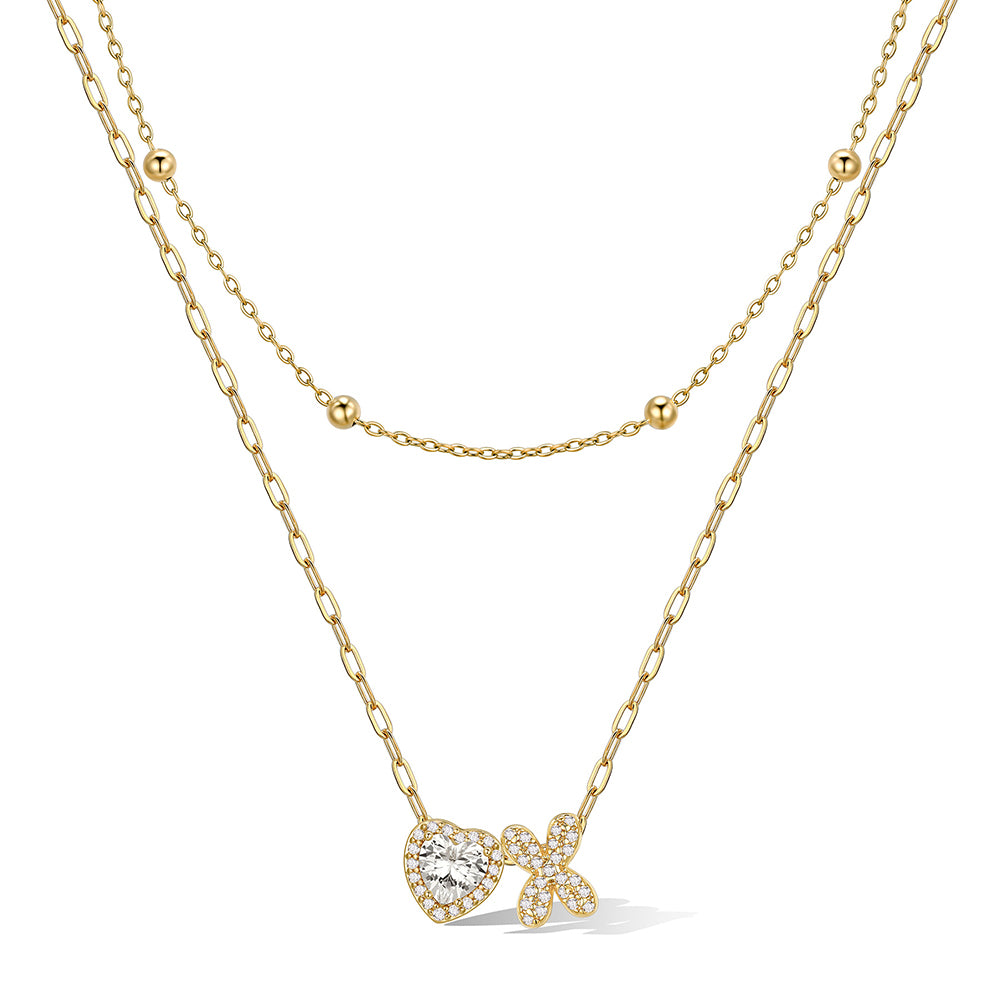 Gold cz bubble initial X necklace with a heart-shaped pendant on a white background