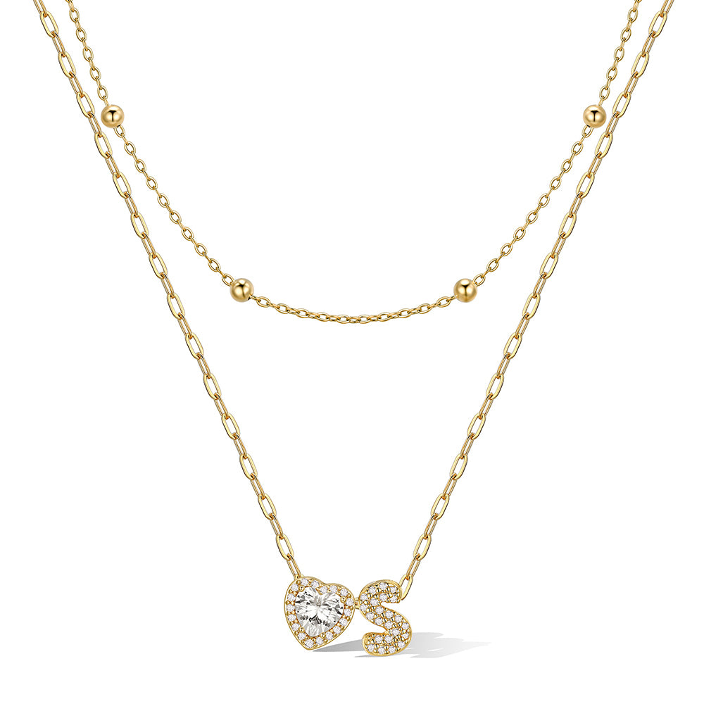 Gold cz bubble initial s necklace with a heart-shaped pendant on a white background