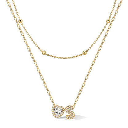 Gold cz bubble initial s necklace with a heart-shaped pendant on a white background