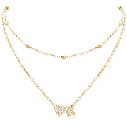 Gold cz initial K necklace with a heart-shaped pendant on a white background