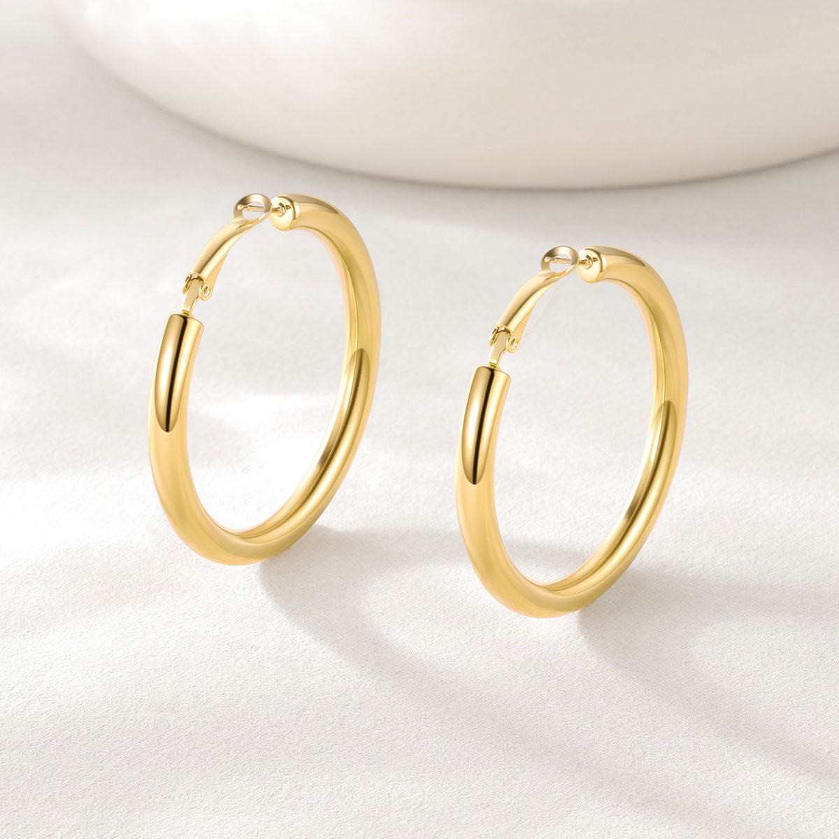 Gold hoop earrings on a light background