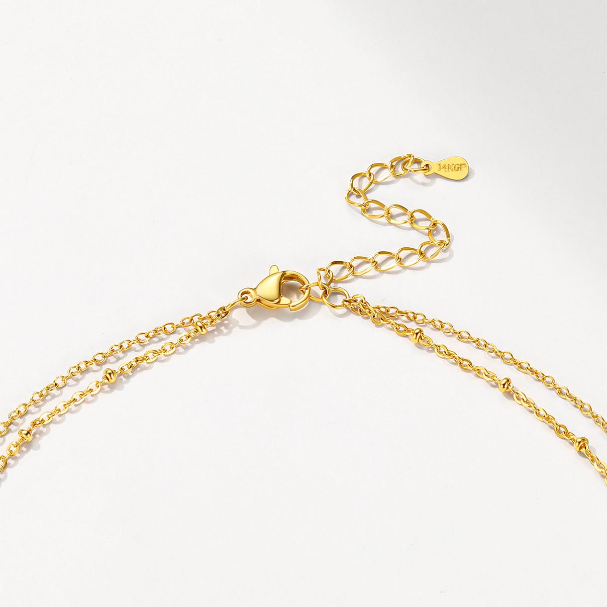 Gold initial necklace with a clasp on a white background