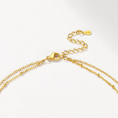 Gold initial necklace with a clasp on a white background