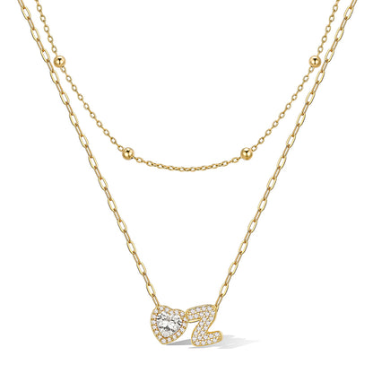 Gold initial necklace with a heart-shaped pendant on a white background