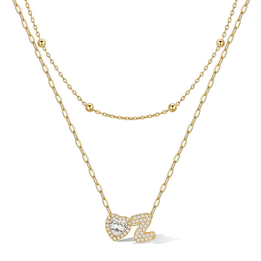 Gold initial necklace with a heart-shaped pendant on a white background
