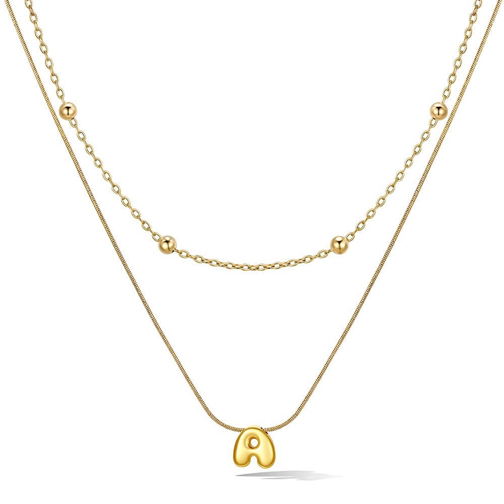 Gold layered initial A necklace, showing measurements and material details.