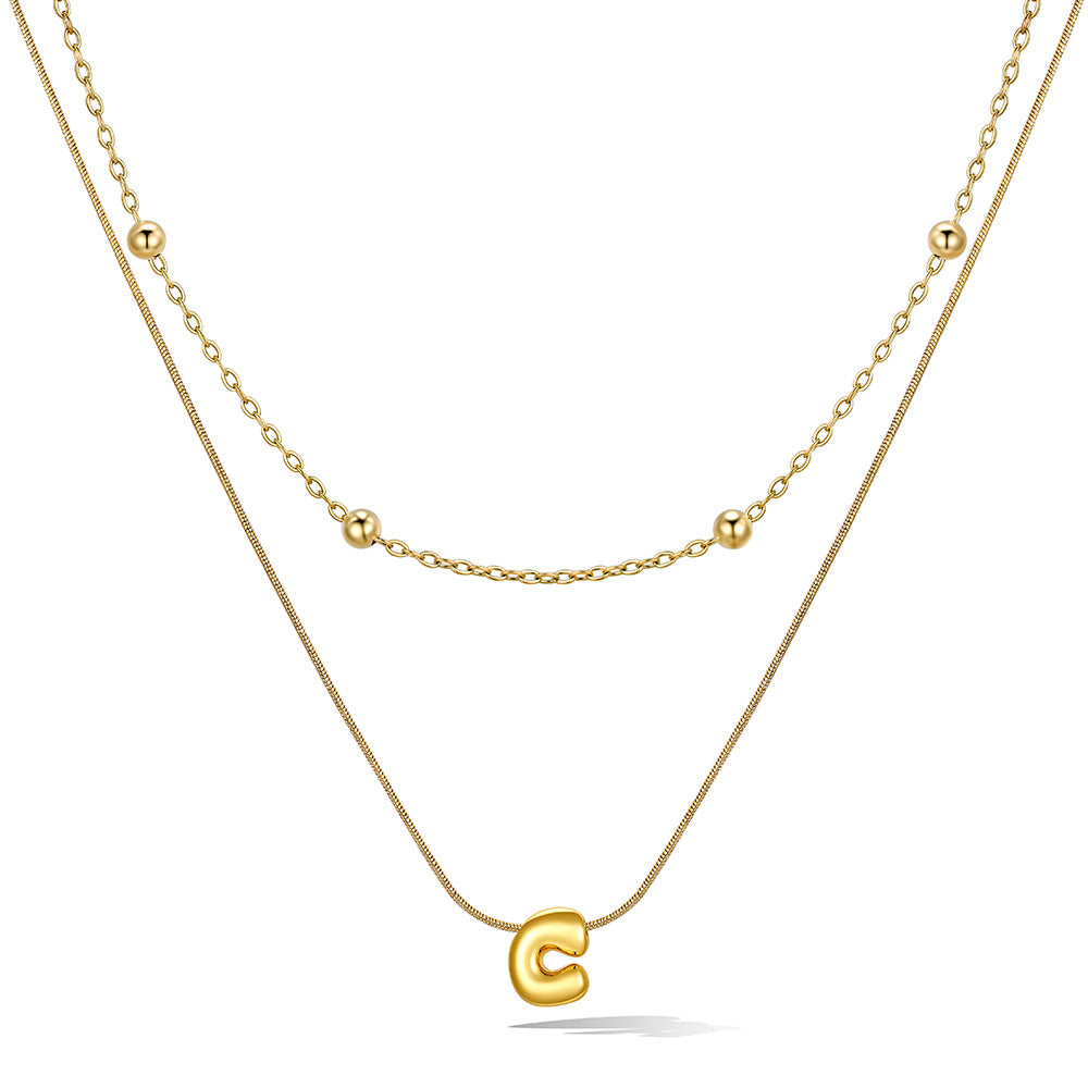 Gold layered initial C necklace, showing measurements and material details.
