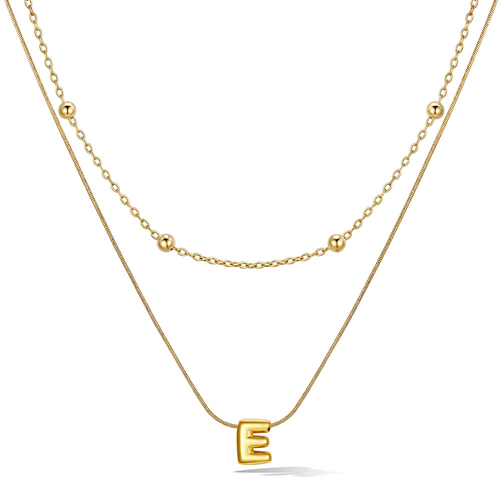 Gold layered initial E necklace, showing measurements and material details.