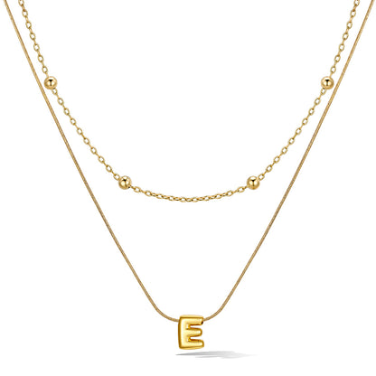 Gold layered initial E necklace, showing measurements and material details.