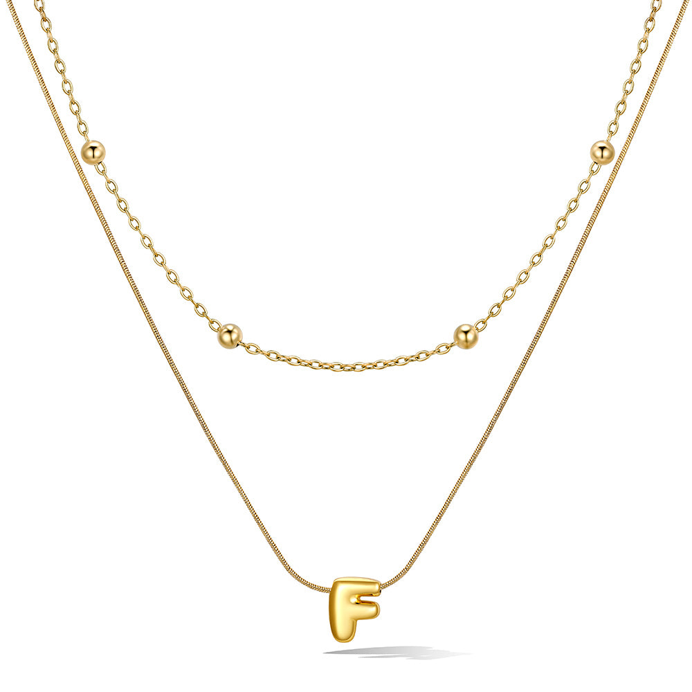 Gold layered initial F necklace, showing measurements and material details.