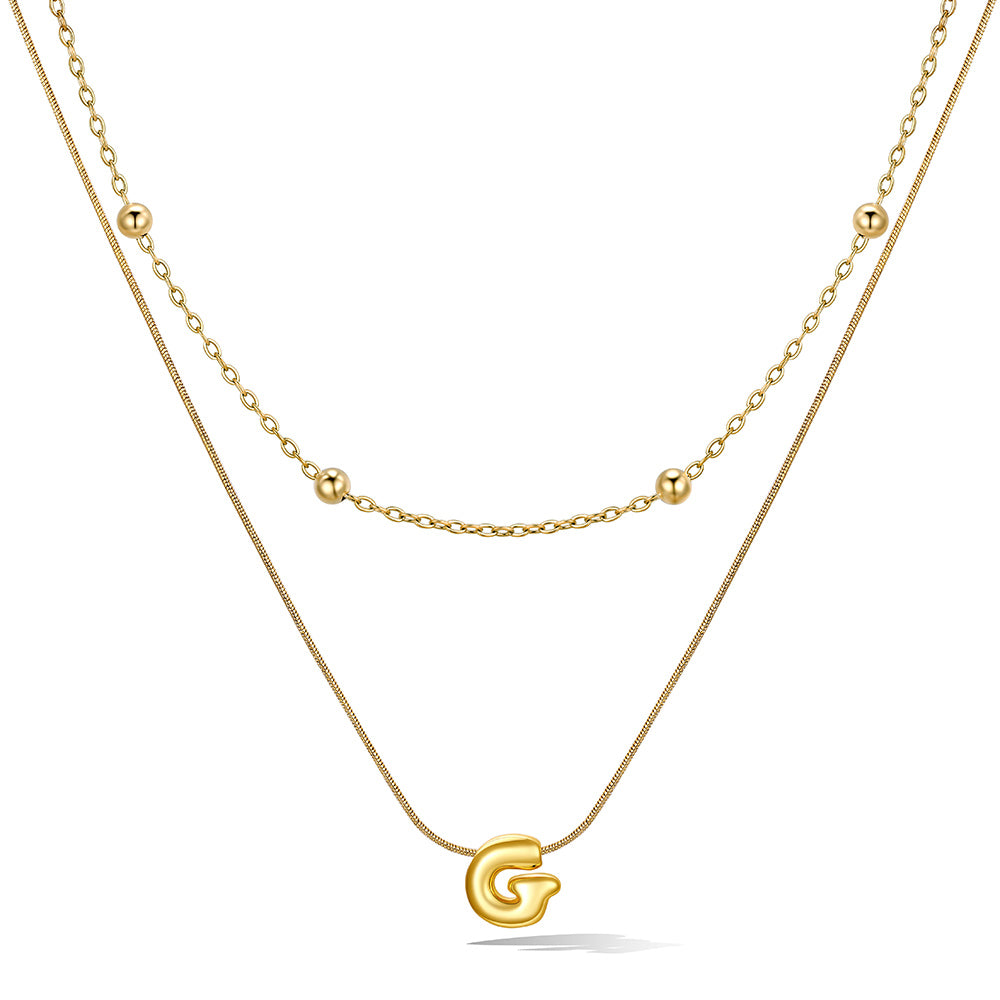 Gold layered initial G necklace, showing measurements and material details.