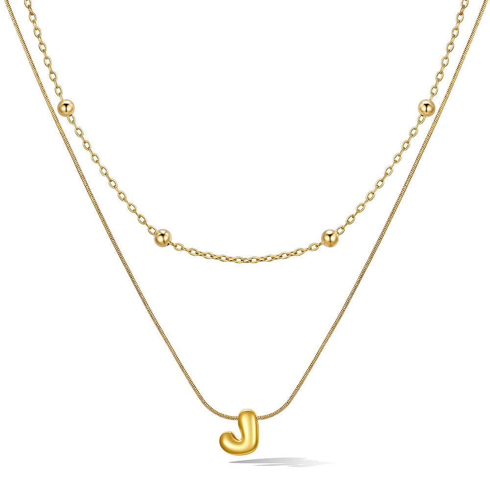 Gold layered initial J necklace, showing measurements and material details.