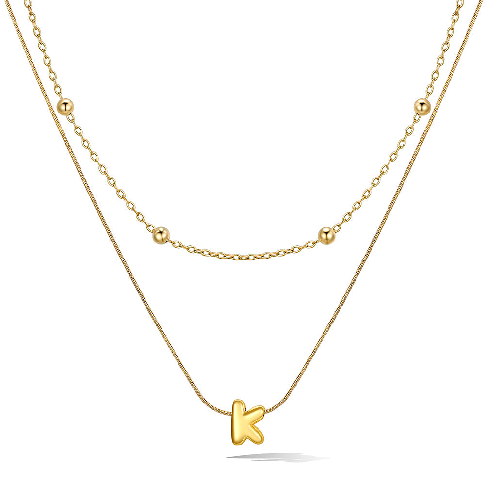 Gold layered initial K necklace, showing measurements and material details.