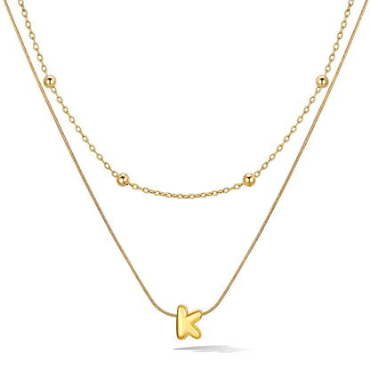 Gold layered initial K necklace, showing measurements and material details.