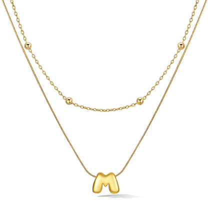 Gold layered initial M necklace with letter 'M' pendant, showing measurements and material details.