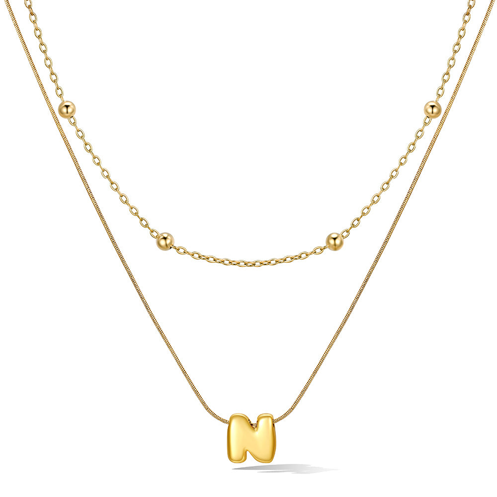 Gold layered initial N necklace with letter 'N' pendant, showing measurements and material details.