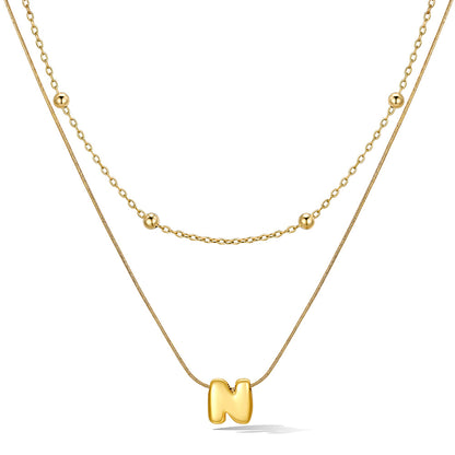 Gold layered initial N necklace with letter 'N' pendant, showing measurements and material details.