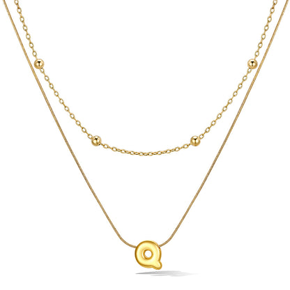 Gold layered initial Q necklace, showing measurements and material details.