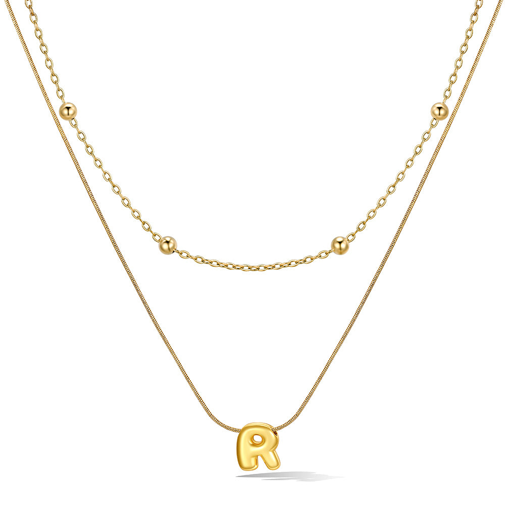 Gold layered initial R necklace with letter 'R' pendant, showing measurements and material details.