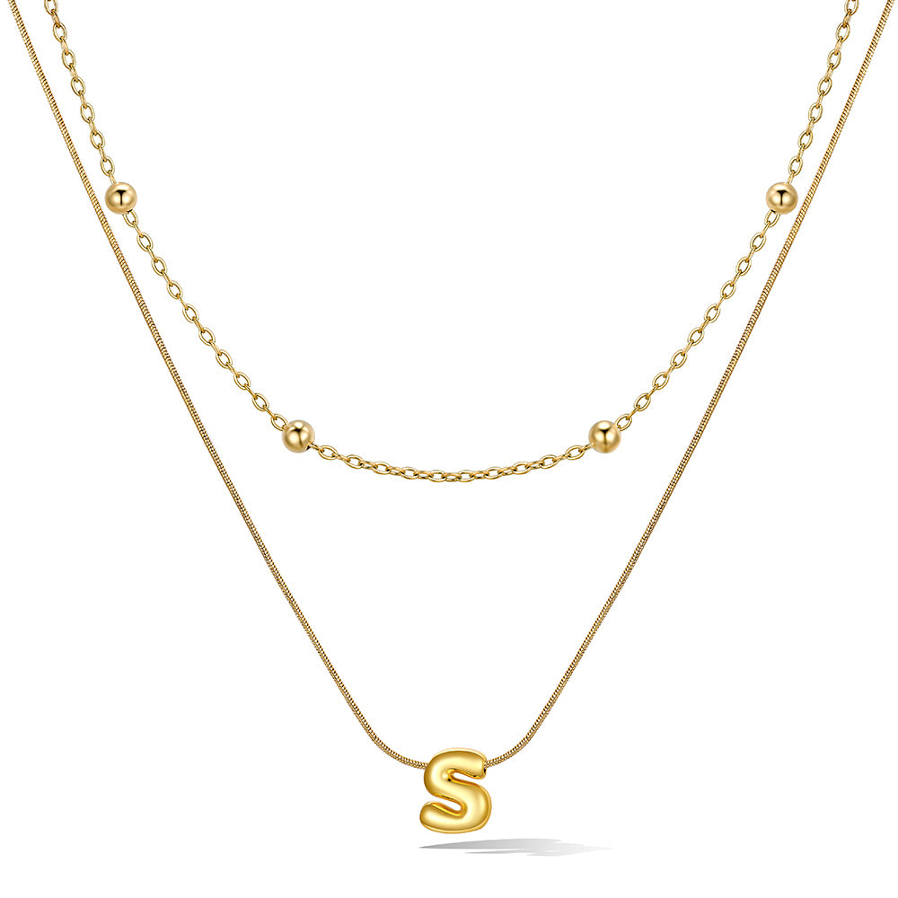 Gold layered initial S necklace with letter 'S' pendant, showing measurements and material details.