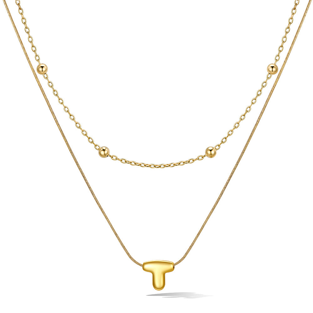 Gold layered initial T necklace with letter 'T' pendant, showing measurements and material details.