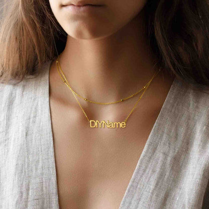 Gold layered name necklace with 'DIYName' pendant worn by a person