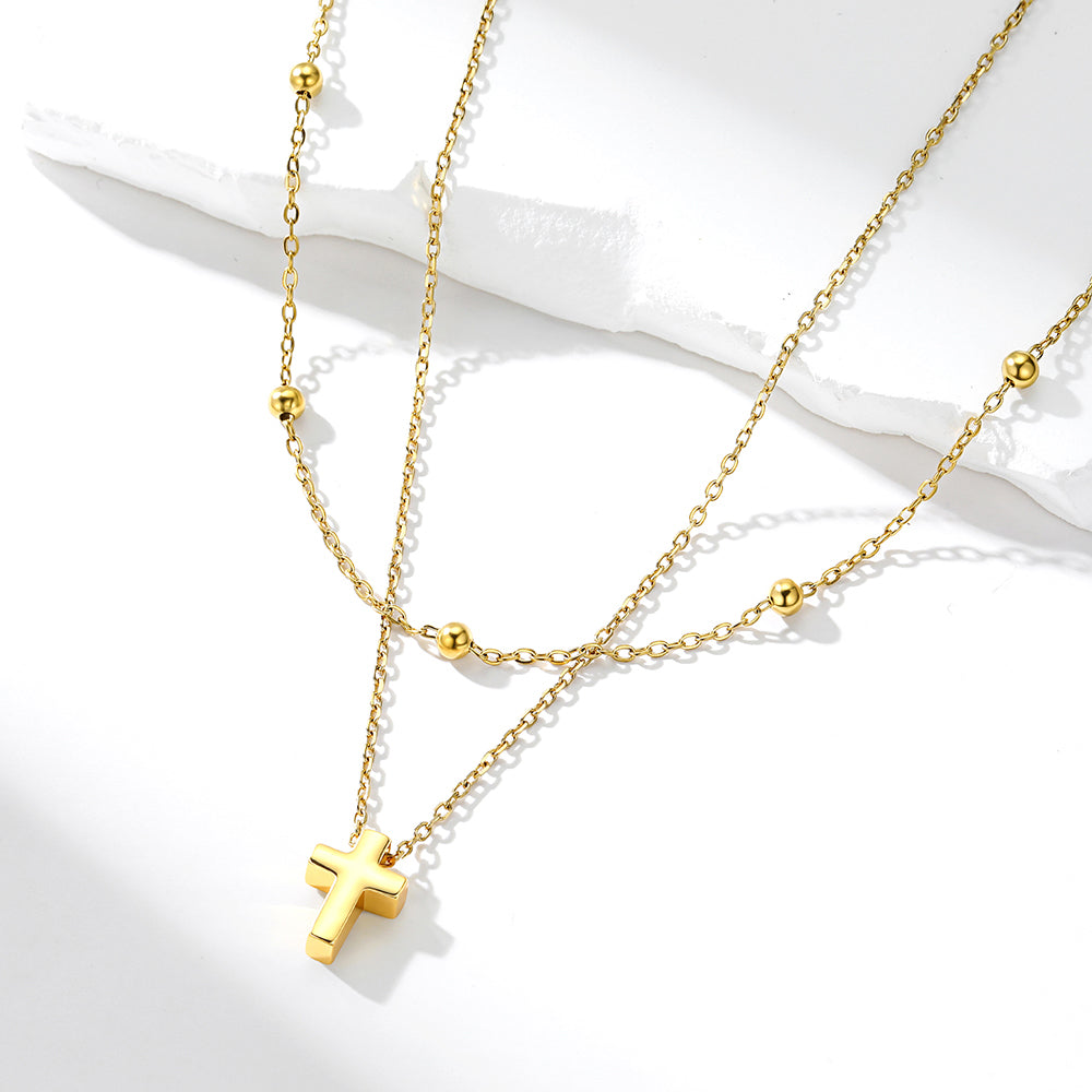 Gold necklace with a cross pendant on a white background