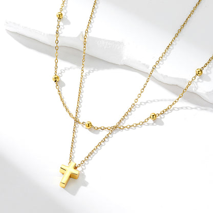 Gold necklace with a cross pendant on a white background