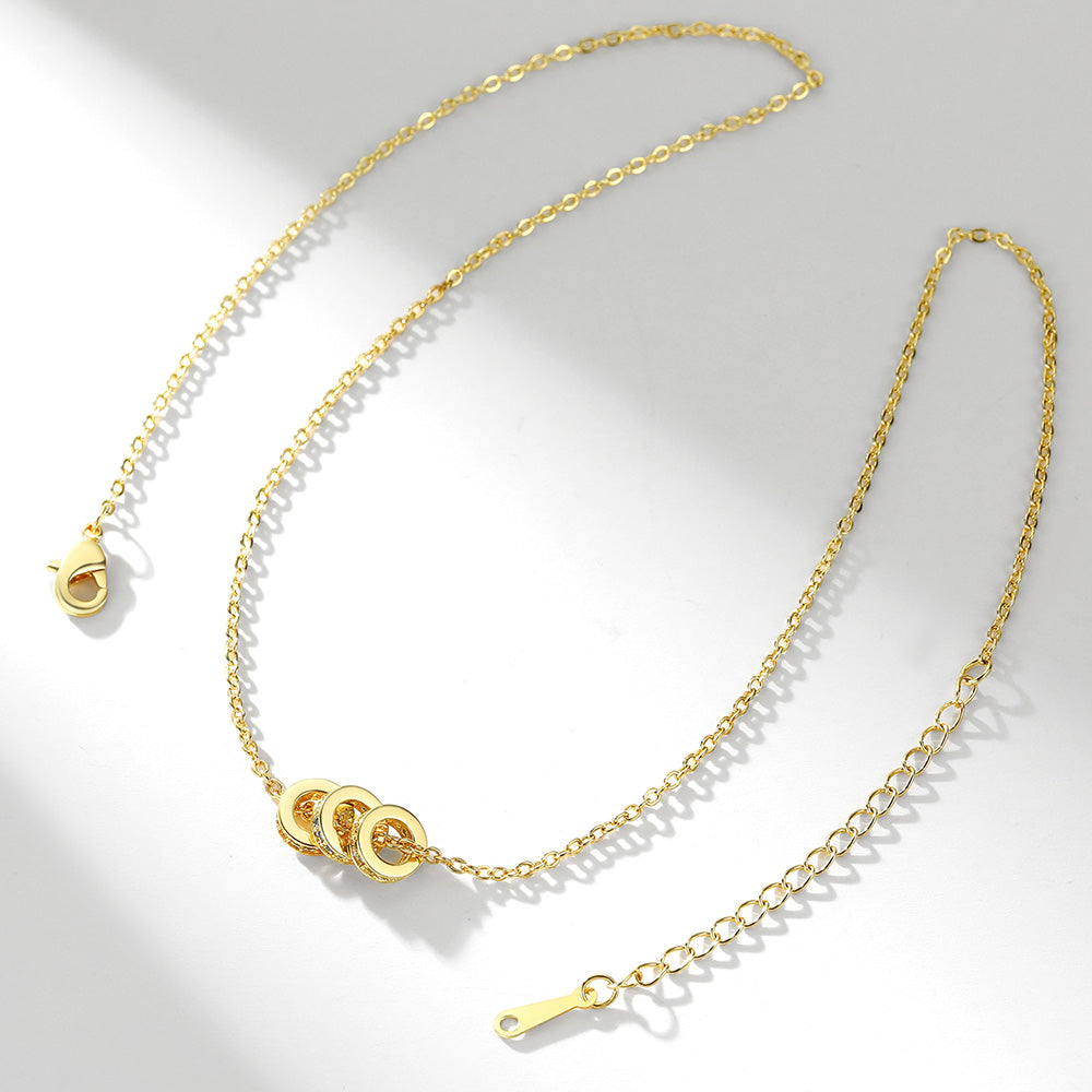 Gold stacking birthstone necklace with a clasp on a light gray background