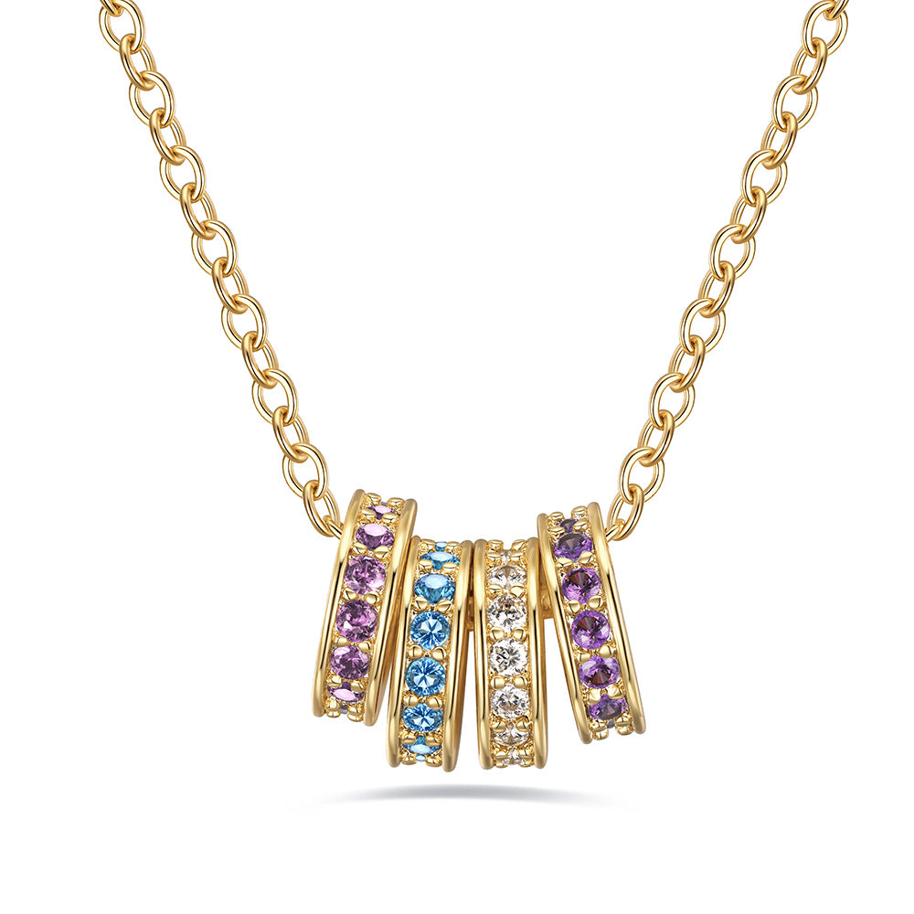Gold stacking birthstone necklace with circular pendants featuring multicolored gemstones on a white background