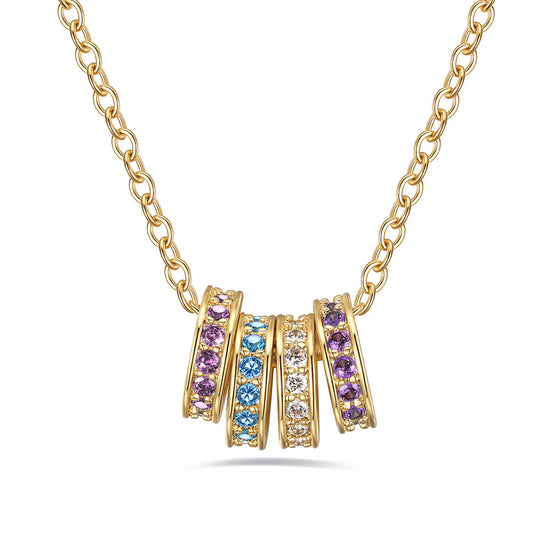 Gold stacking birthstone necklace with circular pendants featuring multicolored gemstones on a white background