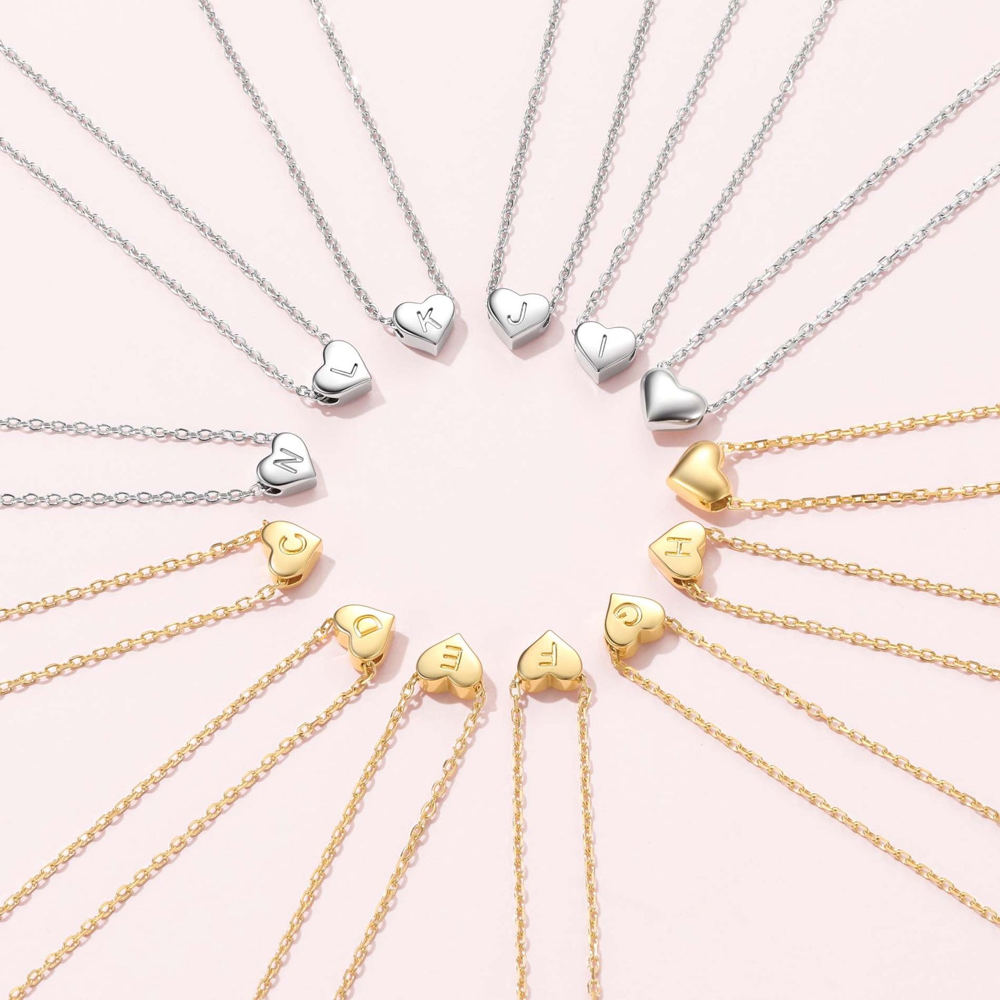 Heart initial Necklaces in silver and gold on a pink background