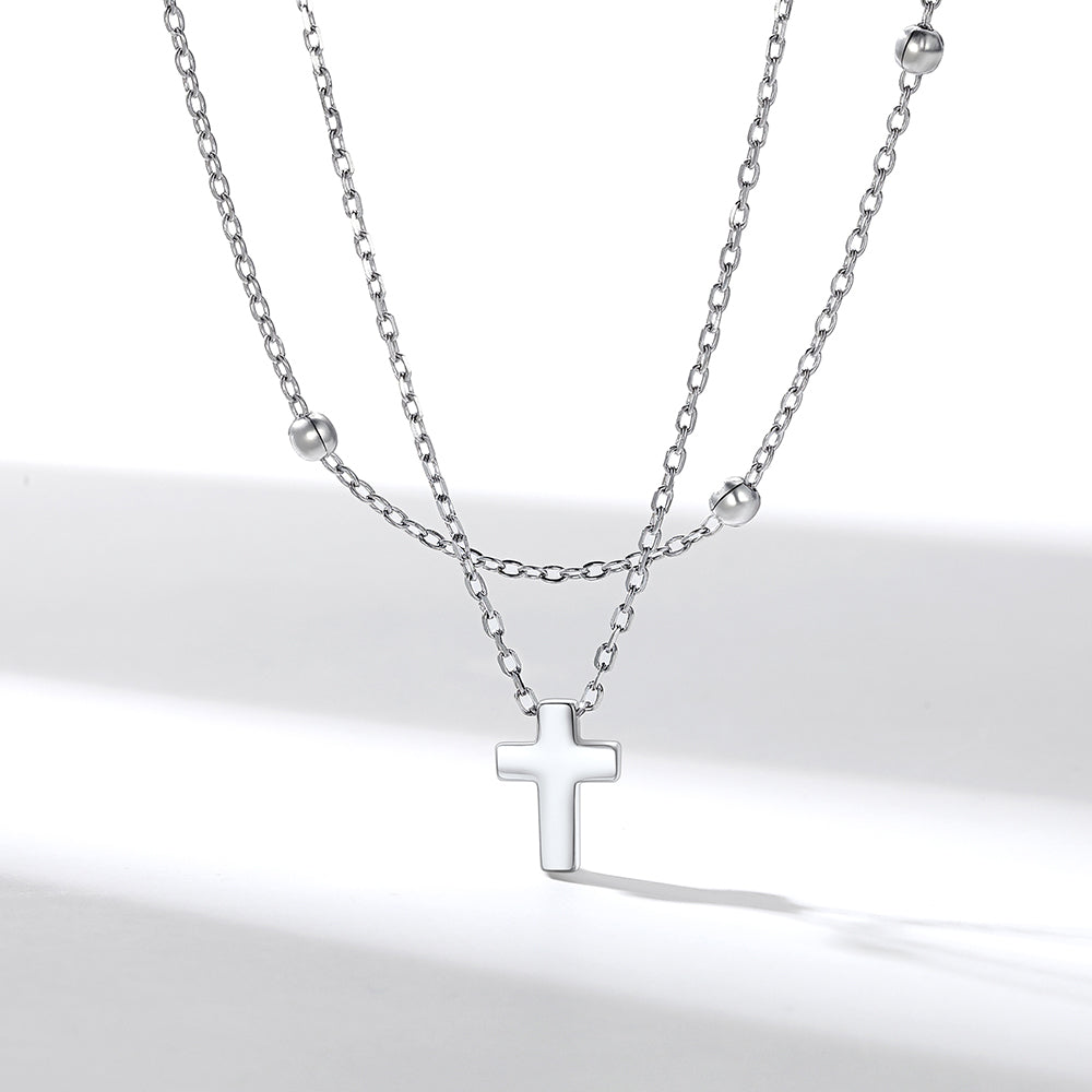 Layered Silver cross necklace on a white background