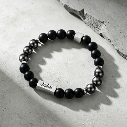 Magnetic Hematite Beaded Bracelet on a cement background