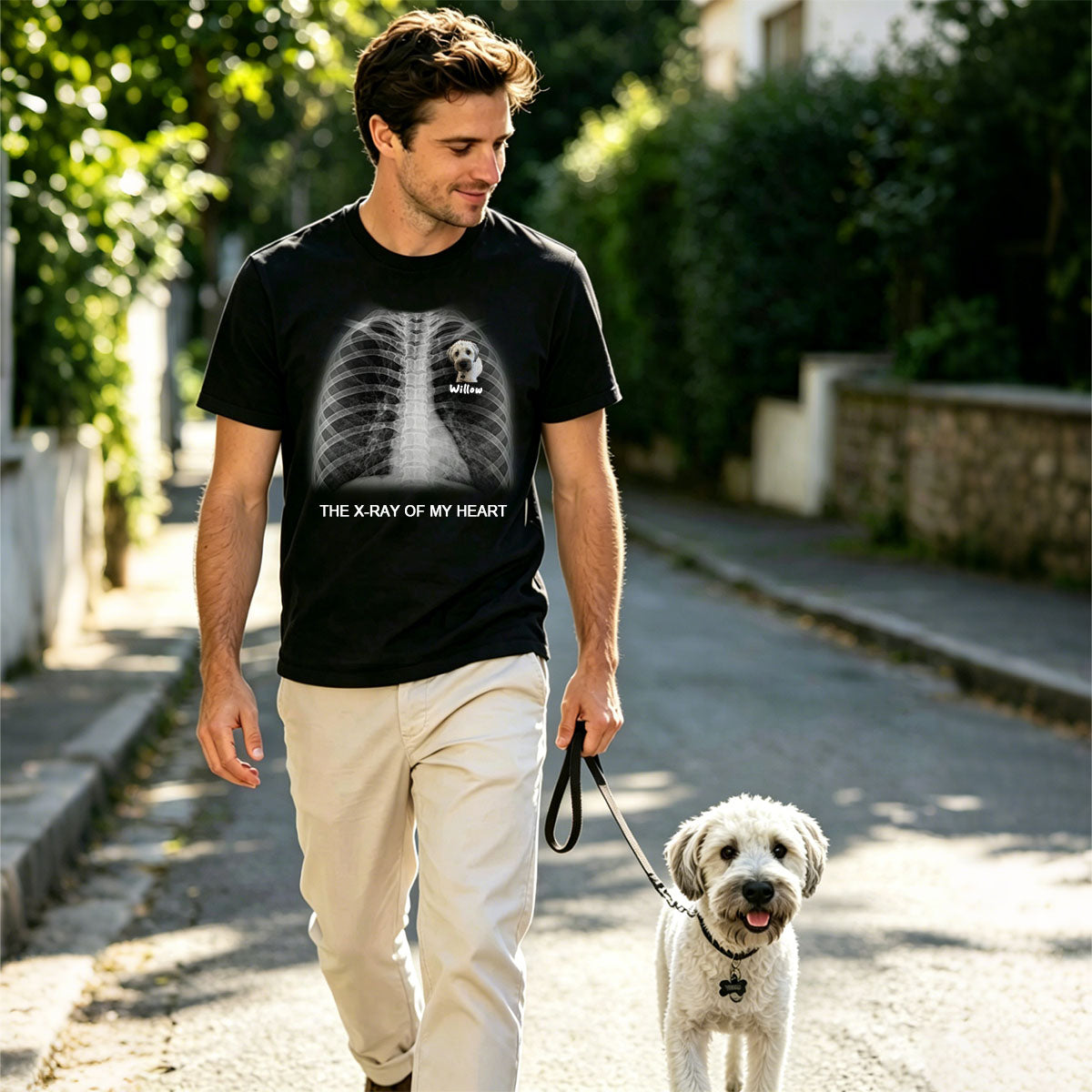Man walking a dog on a leash in a residential area wearing a black custom text X-Ray t-shirt with a graphic design.