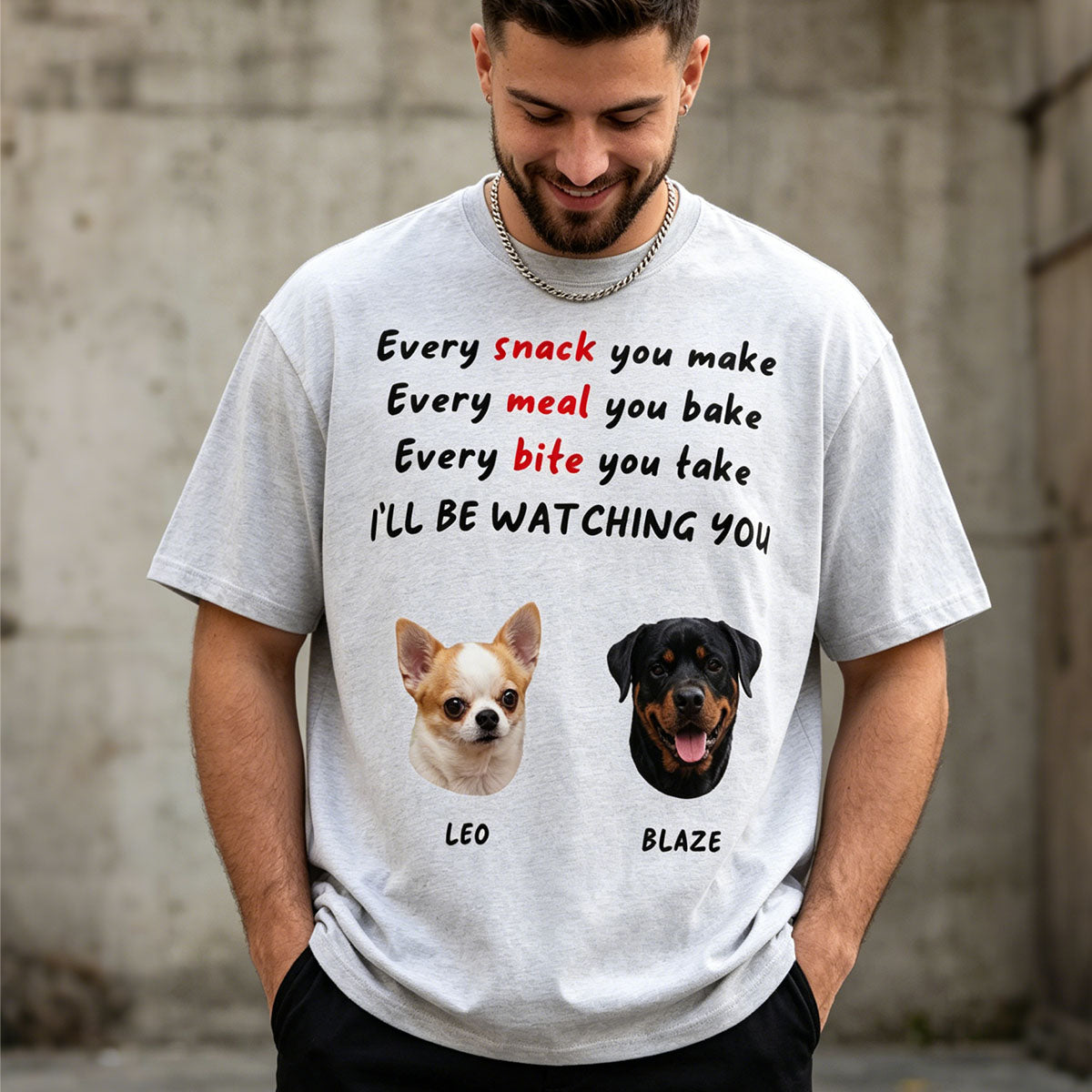 Man wearing a t-shirt with dog illustrations and text against a concrete wall.