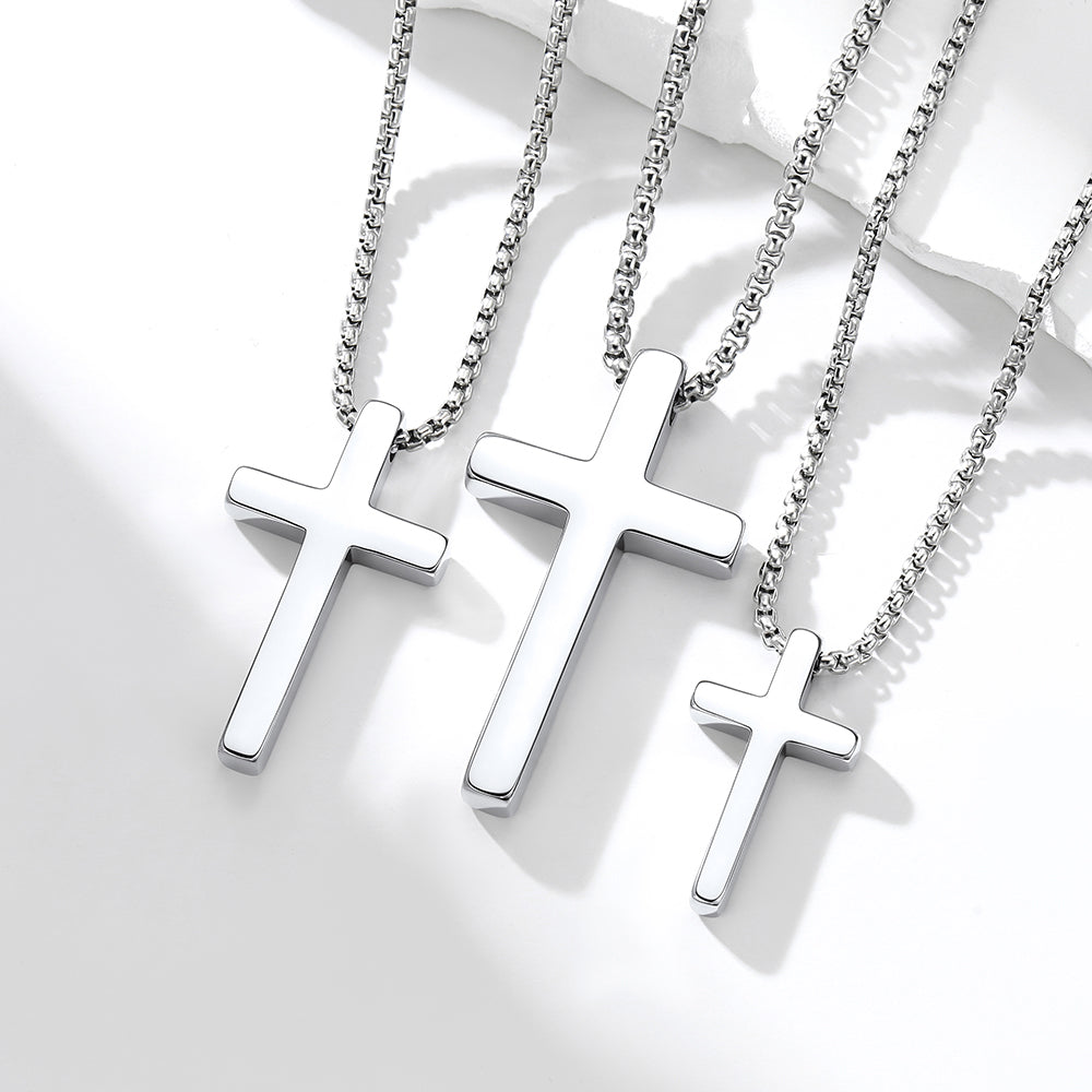 Three silver cross necklaces on a white background