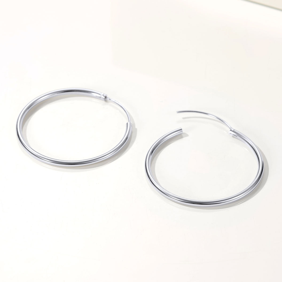 Pair of silver hoop earrings on a white background