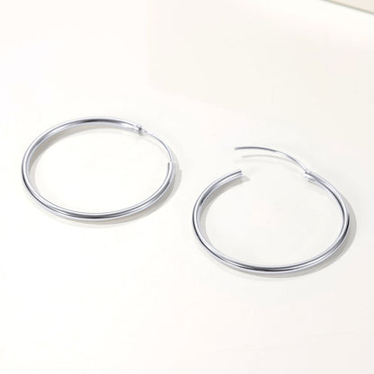 Pair of silver hoop earrings on a white background