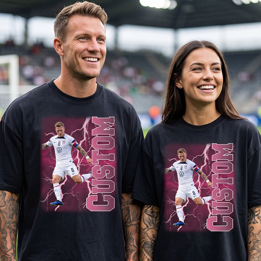 Two people wearing black t-shirts with a soccer player graphic and 'CUSTOM' text, standing on a sports field.