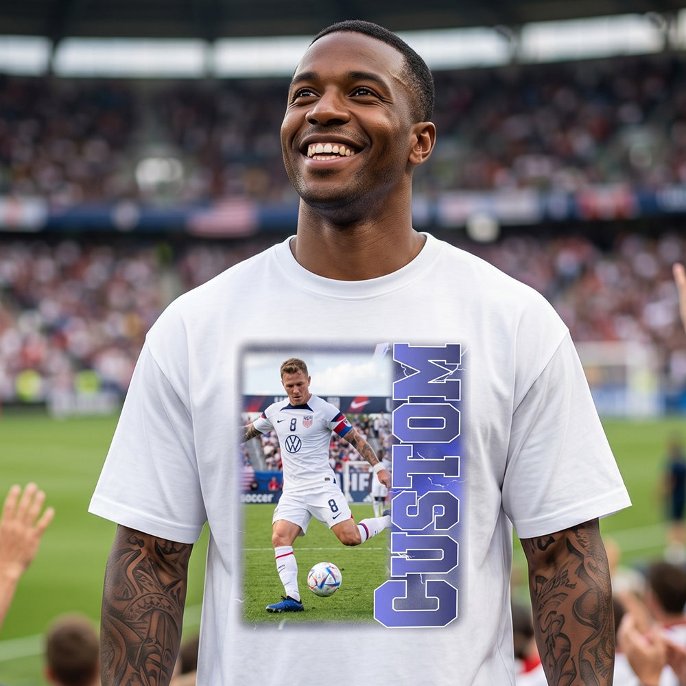 Man wearing a white t-shirt with a soccer player graphic and 'CUSTOM' text in a stadium setting