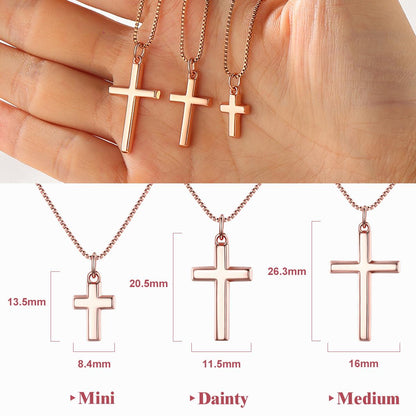Rose gold cross necklaces of different sizes held by a hand, with measurements displayed.