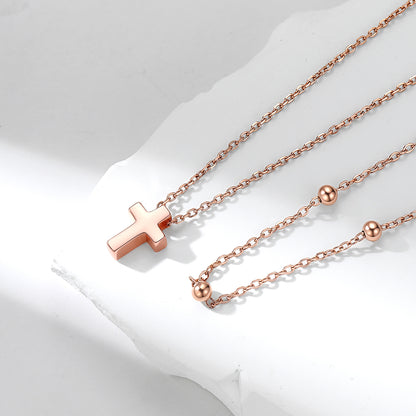 Rose gold necklace with a cross pendant on a white background
