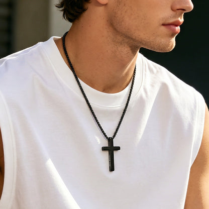 Man wearing a white sleeveless shirt and a black cross necklace.