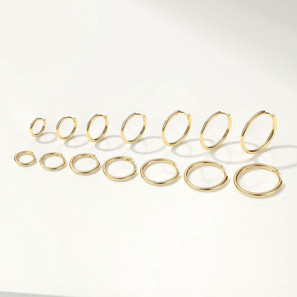Set of gold huggie earrings on a white background