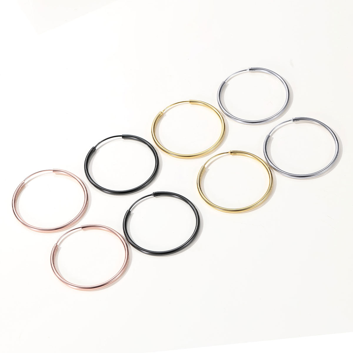 Set of hoop earrings in various colors on a white background