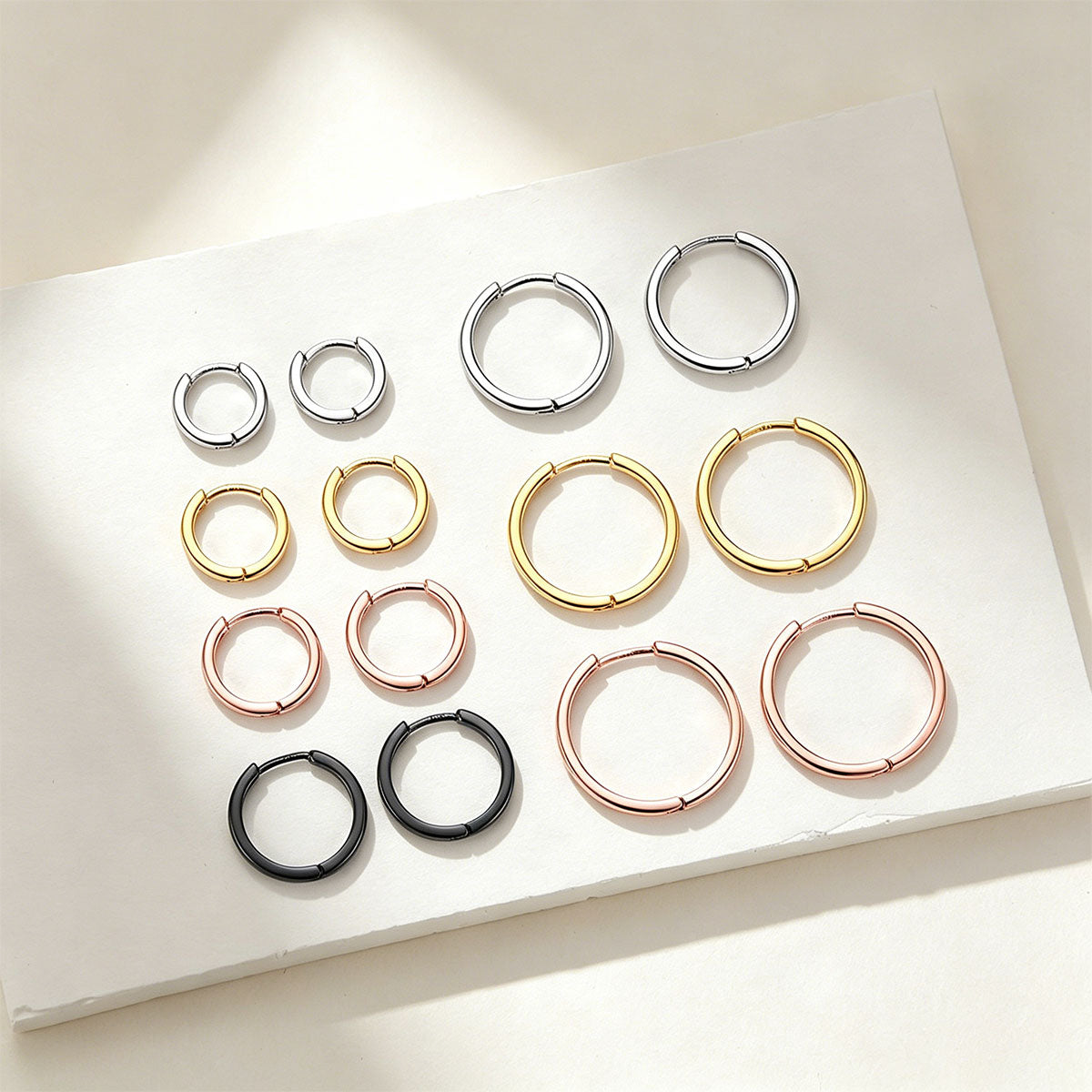 Set of hoop earrings in various colors on a white surface