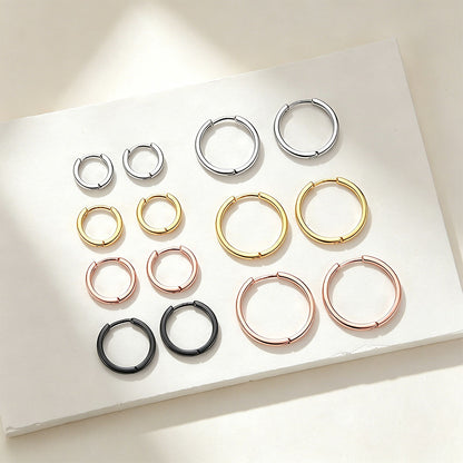 Set of hoop earrings in various colors on a white surface