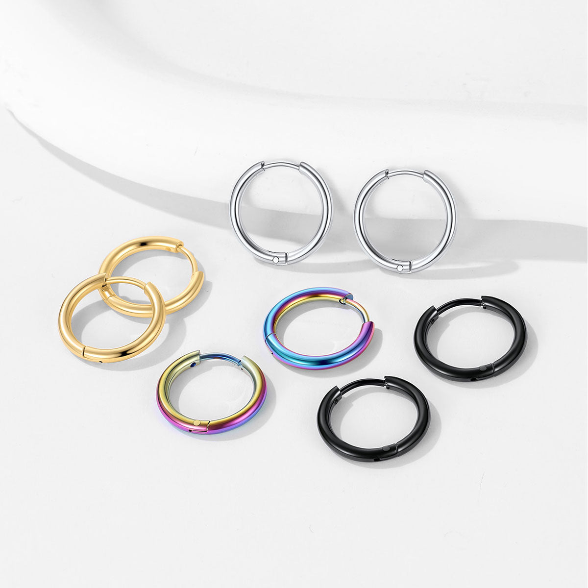 Set of huggie earrings in various colors on a white background
